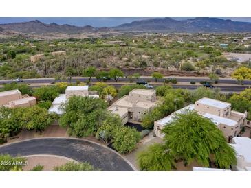 Scenic aerial view showcases the property's lush landscaping and the stunning mountain backdrop at 39016 N Habitat Cir, Cave Creek, AZ 85331