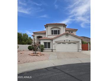 Charming two-story home with stucco exterior, red tile roof, and well-manicured desert landscaping at 5952 W Morning Dove Dr, Glendale, AZ 85308