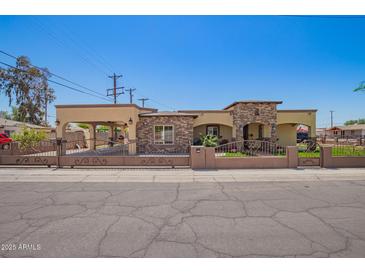Charming home featuring beautiful stonework, a gated yard, and a covered parking area at 6459 W Columbus Ave, Phoenix, AZ 85033