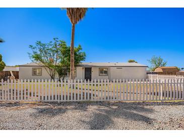 Inviting single-story home with a secure white picket fence and desert landscaping for low maintenance at 7011 W Carol Ann Way, Peoria, AZ 85382