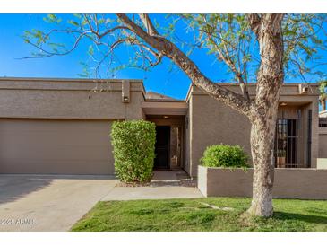 Charming single-level home featuring a two-car garage and beautifully landscaped front yard at 7962 E San Miguel Ave, Scottsdale, AZ 85250
