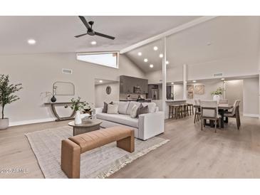 Open-concept living room featuring a fireplace, high ceilings, and seamless flow into the dining area at 7962 E San Miguel Ave, Scottsdale, AZ 85250