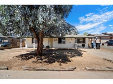 Charming single-story home with a large tree, inviting curb appeal, and a well-maintained exterior at 8042 N 28Th Ave, Phoenix, AZ 85051