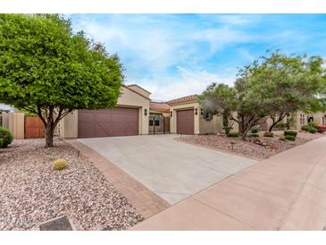 Charming single-story home with a three-car garage, desert landscaping, and a gated courtyard entry at 12906 W Oyer Ln, Peoria, AZ 85383