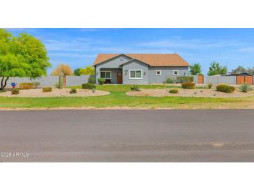 Charming single-story home features a desert landscape, lush lawn and a welcoming facade at 14415 N 184Th Ave, Surprise, AZ 85388