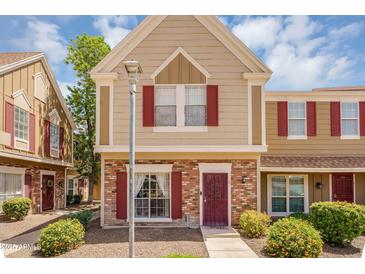 Charming multi-level home featuring brick accents, red shutters and a welcoming walkway leading to the front door at 18811 N 34Th Ave # 6, Phoenix, AZ 85027