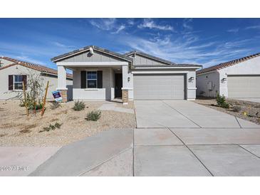 Charming single-story home featuring a two-car garage and low maintenance desert landscaping at 22045 N Rummler Ln, Maricopa, AZ 85138