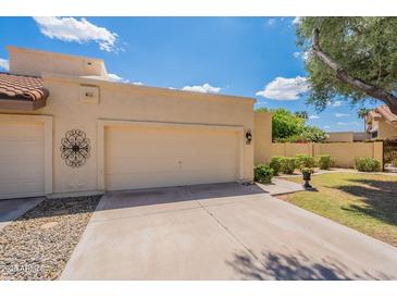 Beige single-Gathering home with a two-car garage, desert landscaping, and lovely curb appeal at 2369 W Shawnee Dr, Chandler, AZ 85224