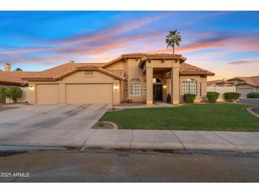 Charming single-story home featuring a three-car garage, desert landscaping, and a tile roof at 3295 S Ambrosia Dr, Chandler, AZ 85248