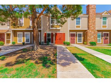 Inviting townhomes with lush landscaping, charming entryways, and mature shade trees along a sidewalk at 3416 W Julie Dr # 4, Phoenix, AZ 85027