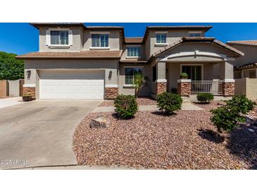 Charming two-story home with a well-manicured landscape featuring neutral tones, stone accents, and a two-car garage at 5973 S Legend Dr, Gilbert, AZ 85298