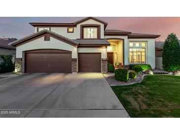 Charming two-story home boasts a three-car garage and meticulous landscaping, enhancing curb appeal at 6449 S Glory Ct, Gilbert, AZ 85298