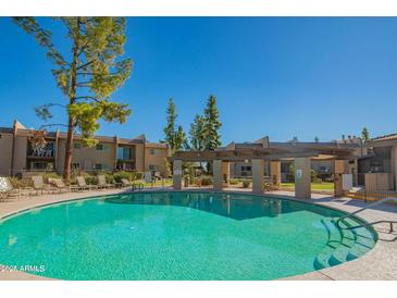 Resort-style pool with lounge chairs and shaded pergola, perfect for relaxation and recreation at 7436 E Chaparral Rd # B246, Scottsdale, AZ 85250