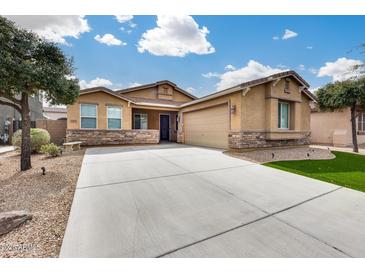 Charming single-story home with a spacious driveway, stone accents, and a well-maintained front yard at 9165 W Mine Trl, Peoria, AZ 85383