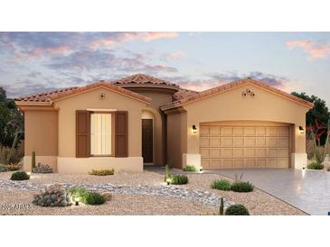 Charming, single-story stucco home featuring a tile roof, desert landscaping, and an attached two-car garage at 10953 N 163Rd Dr, Surprise, AZ 85388