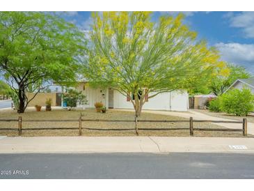 Charming home featuring desert landscaping with vibrant trees and a rustic fence at 2901 W Mandalay Ln, Phoenix, AZ 85053