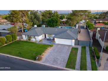 Aerial view of single-story home with a large yard, block fence, gated driveway and private backyard pool at 3027 W Wescott Dr, Phoenix, AZ 85027