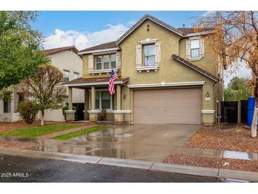 Two-story home with neutral colored stucco, American flag, covered entry, and landscaped yard at 3432 E Bartlett Dr, Gilbert, AZ 85234