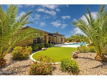 Lush backyard with artificial grass, desert landscaping, and covered patio, perfect for outdoor living at 5330 S Big Horn Pl, Chandler, AZ 85249