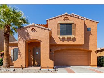 Charming two-story home featuring a stucco exterior, a terracotta roof, and a well-manicured front yard with desert landscaping at 7204 S Golfside Ln, Phoenix, AZ 85042