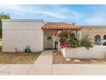 Charming home exterior with colorful foliage, decorative wreath, and a covered front entry at 870 S Palm Ln # 55, Chandler, AZ 85225