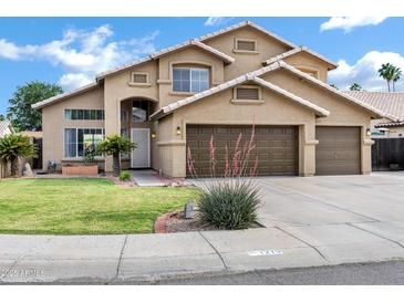 Inviting two-story home with a well-manicured lawn and a spacious three-car garage at 1215 W Wahalla W Ln, Phoenix, AZ 85027