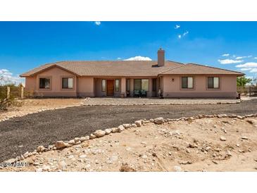 Charming single-story home featuring a well-manicured front yard and a welcoming entrance under a partly cloudy sky at 20041 W Colter St, Litchfield Park, AZ 85340