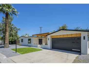 Single Gathering home with minimalist landscaping and a modern dark garage door at 47 Spur Cir, Scottsdale, AZ 85251