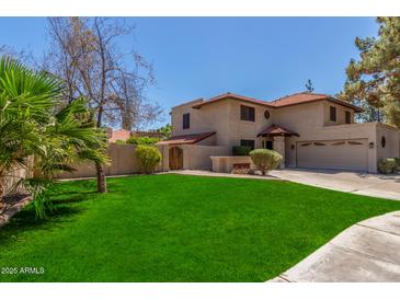 Charming two-story home with a well-manicured lawn and a terracotta tile roof at 635 N Yale Dr, Gilbert, AZ 85234