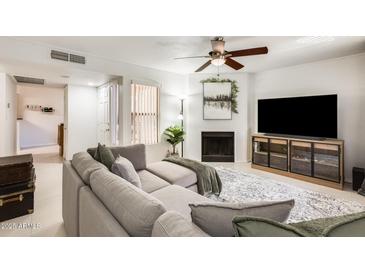Inviting living room featuring a large sectional sofa, fireplace, and entertainment center at 8787 E Mountain View Rd # 1029, Scottsdale, AZ 85258