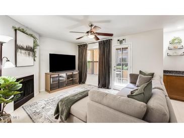 Bright living room with a neutral color palette, comfortable couch, and a cozy fireplace at 8787 E Mountain View Rd # 1029, Scottsdale, AZ 85258