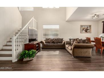 Bright living room with high ceilings, wood floors, staircase, and comfortable seating at 11429 W Yavapai St, Avondale, AZ 85323