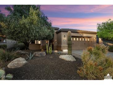 Charming home with desert landscaping, including a mature tree and various cacti at dusk at 12972 W Kokopelli Dr, Peoria, AZ 85383