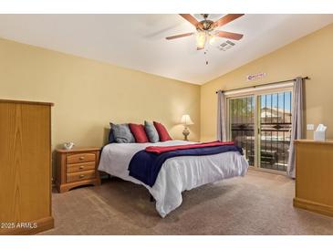 Bright bedroom with a ceiling fan, sliding glass door, and a comfortable bed with colorful pillows and blankets at 174 W Del Rio St, Gilbert, AZ 85233