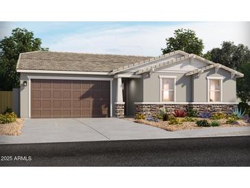 Charming one-story home with a two-car garage, stone accents, and a beautifully landscaped front yard at 17703 W Ford St, Goodyear, AZ 85338