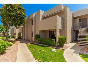 Beige two-story condo building with a lush green lawn and sidewalk at 1920 W Lindner Ave # 116, Mesa, AZ 85202