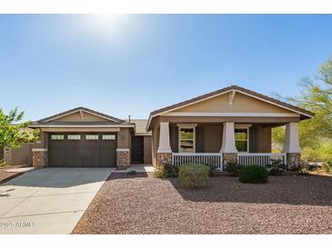 Charming single-story home featuring a welcoming front porch and a well-maintained desert landscape at 2674 N Saide Ln, Buckeye, AZ 85396