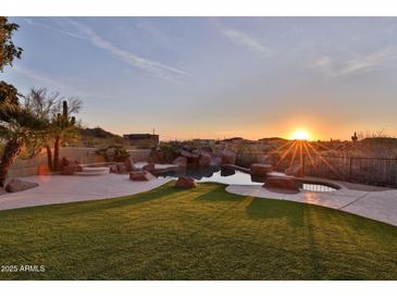 Stunning backyard pool with rock features and sunset view, perfect for outdoor relaxation and entertaining at 2918 N 90Th St, Mesa, AZ 85207