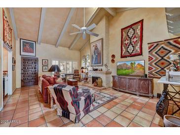 Cozy living room with high ceilings, tile floors, a fireplace, and southwestern decor at 5738 N Scottsdale Rd, Scottsdale, AZ 85253