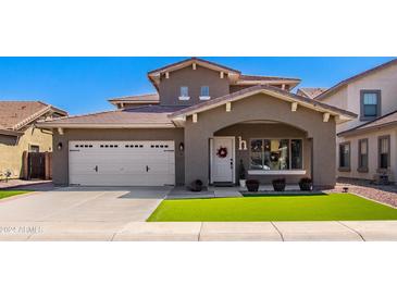 Charming two-story home featuring an attached two-car garage and well-manicured landscaping at 961 E Blue Spruce Ln, Gilbert, AZ 85298