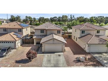 Two-story home featuring a tile roof, two-car garage, and desert landscaping for low maintenance at 11915 W Charter Oak Rd, El Mirage, AZ 85335