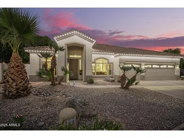 Charming home featuring a rock garden, well-maintained landscaping, and warm lighting at 2406 E Oakland St, Chandler, AZ 85225
