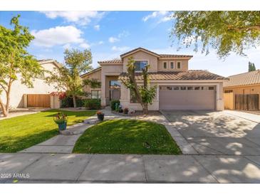 Charming two-story home with landscaped yard and a two car garage under a sunny, blue sky at 285 W Goldfinch Way, Chandler, AZ 85286