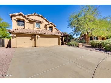 Inviting home featuring a three-car garage, desert landscaping, and a tile roof at 29023 N 46Th Way, Cave Creek, AZ 85331