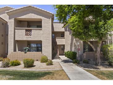 Exterior view of a tan-colored building with balconies and lush green landscaping at 29606 N Tatum Blvd # 174, Cave Creek, AZ 85331