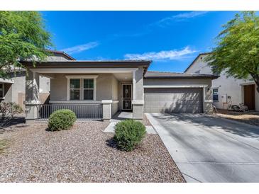 Charming single-story home with a two-car garage, covered porch, and low-maintenance desert landscaping at 42180 W Cheyenne Dr, Maricopa, AZ 85138