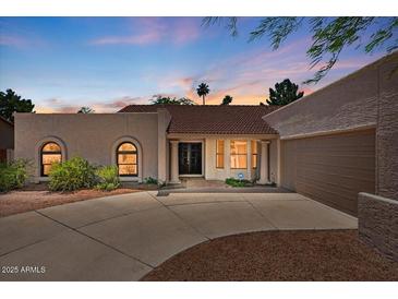 Charming single-story home with a red tile roof, neutral stucco, and a spacious driveway at sunset at 509 W Boxelder Pl, Chandler, AZ 85225