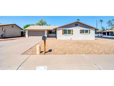 Charming single story exterior with a gravel yard, white painted brick, and attached two car garage at 8 S Cholla St, Gilbert, AZ 85233