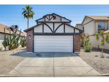 Charming home featuring a two-car garage, red brick accents, and a well-manicured front yard with desert landscaping at 1915 S 39Th St # 37, Mesa, AZ 85206