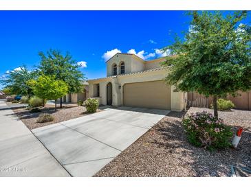 Charming stucco home with a two-car garage and manicured landscaping, perfect for curb appeal at 20251 W Hadley St, Buckeye, AZ 85326